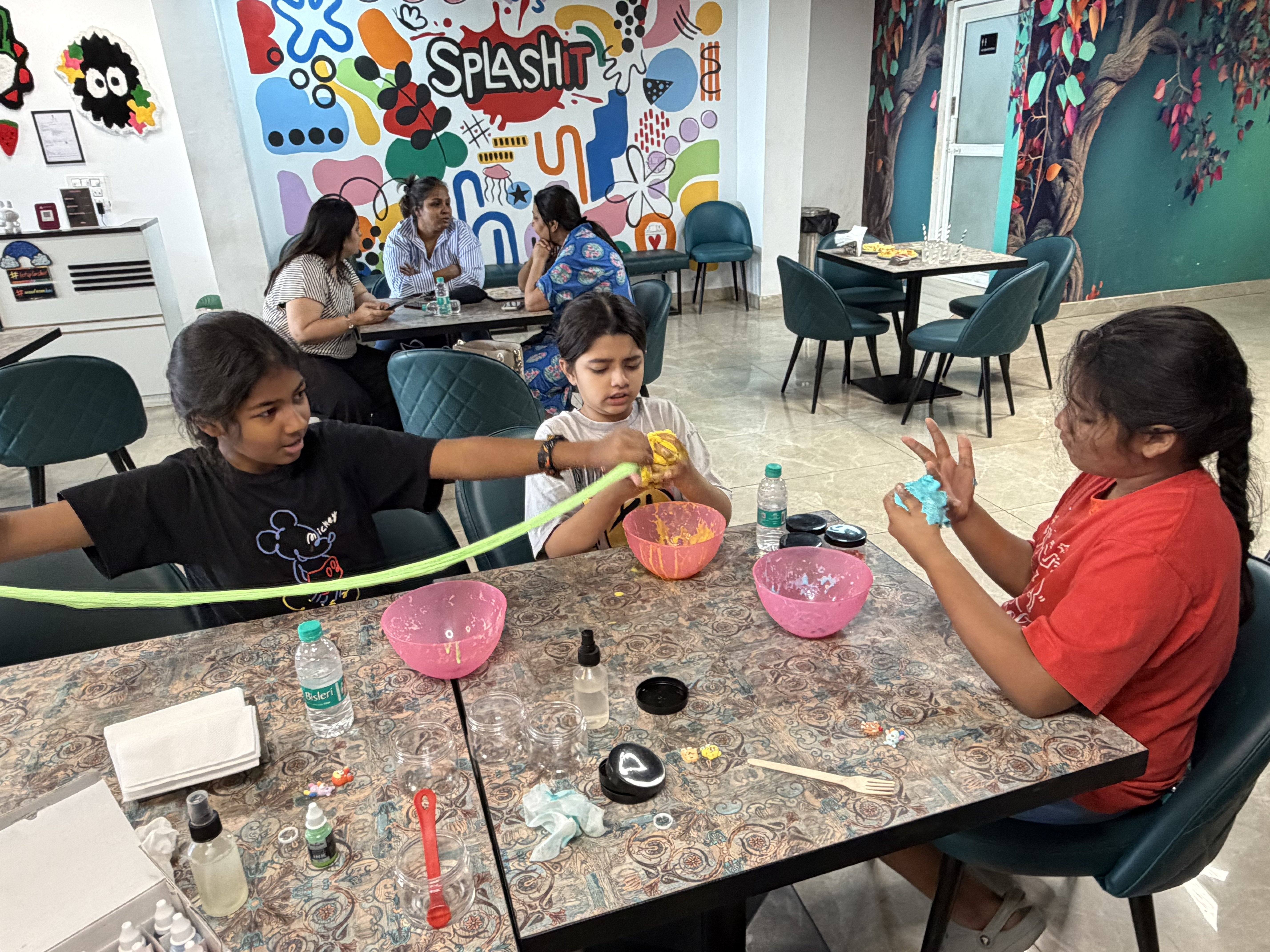Child making colourful glitter slime at Splashit slime lab